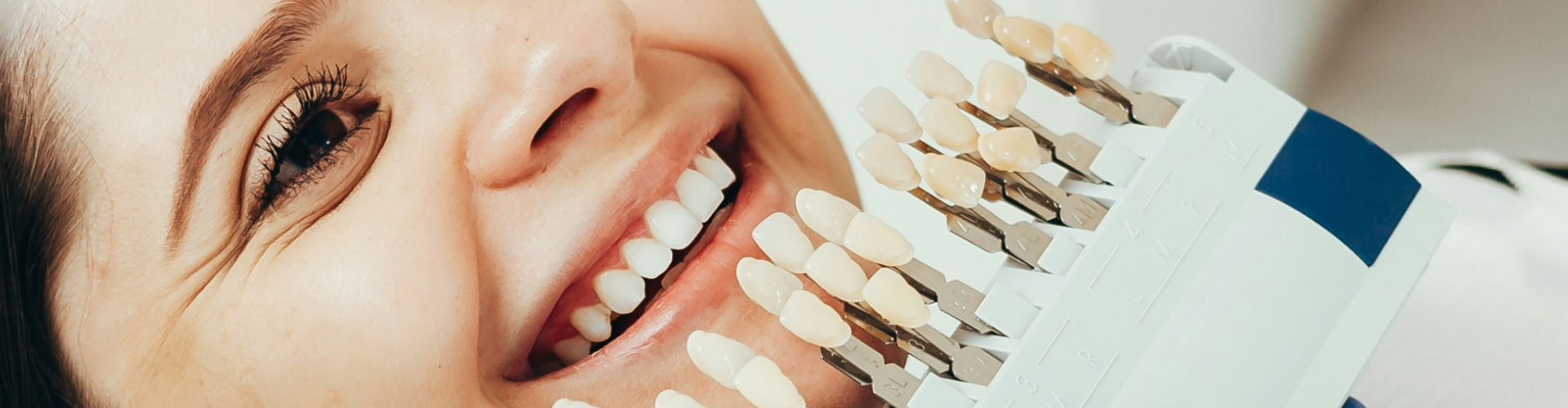 Tooth shade-matching tool next to woman's smile.